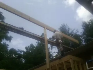 Carpenter setting a ridge beam over a new addition frame — Ice Dam Removal by Roofing Brothers in Mission Hill