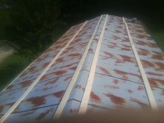 Rusted metal roof panels with new wood purlins before replacement — Storm Damage Roof Repair in Mission Hill by Roofing Brothers