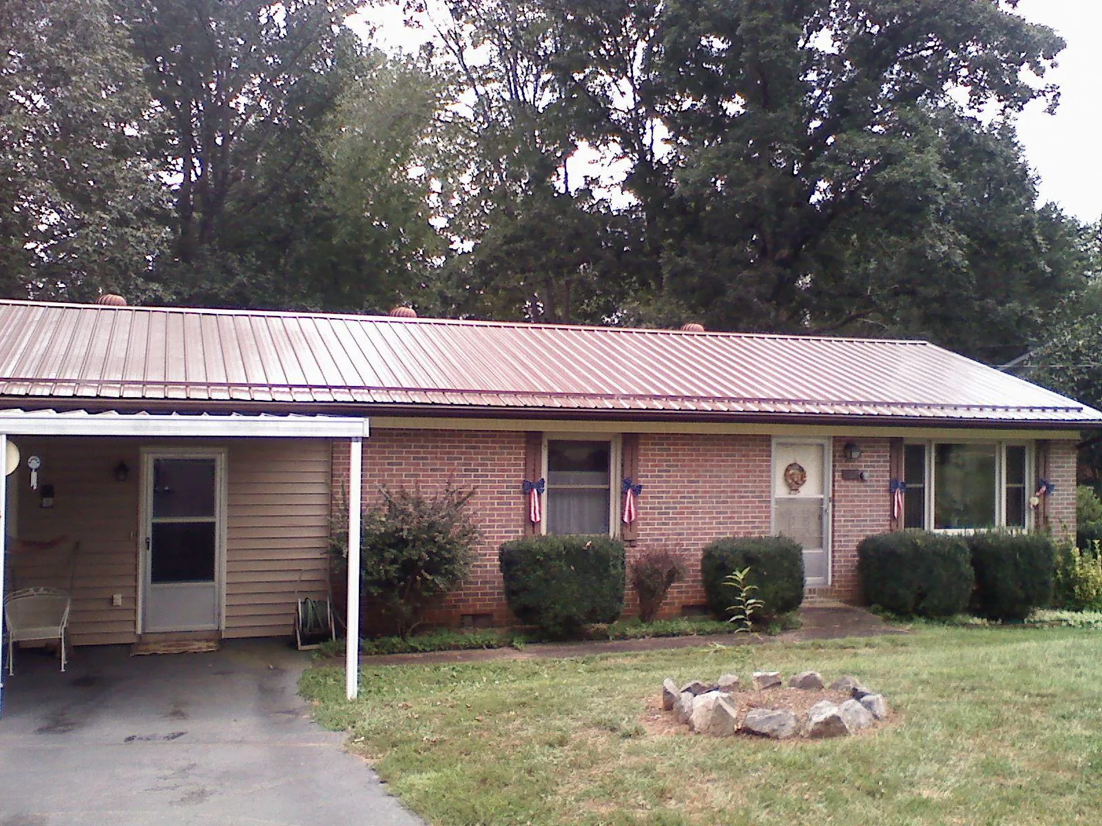 Bronze metal roof and carport on a brick ranch home — Roof Repair work by our crew in Mission Hill